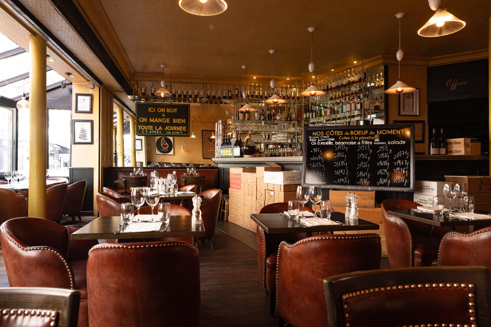 Salle du restaurant À Côté : fauteuils club en cuir, bar et ardoise des côtes de bœuf du moment avec leurs poids