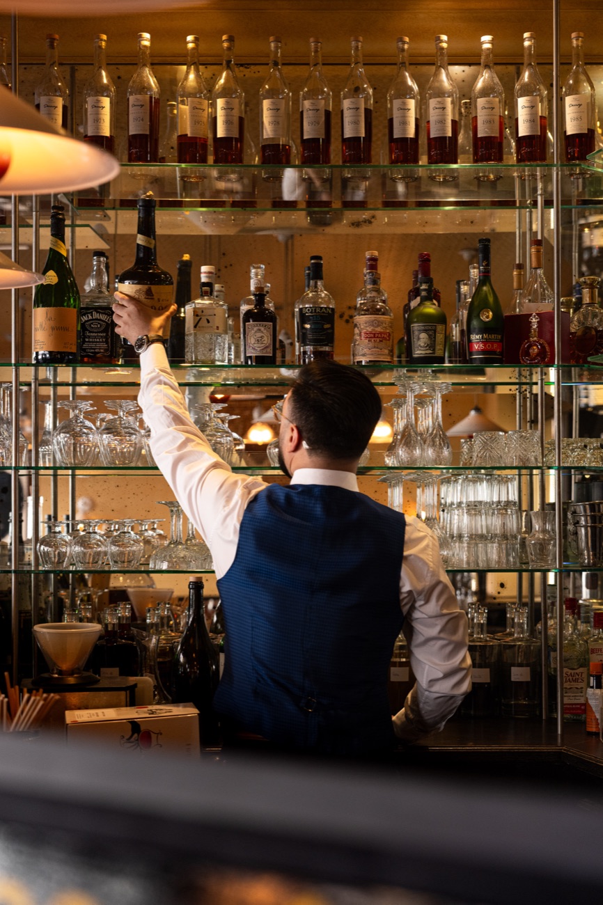 Barman au comptoir devant les spiritueux